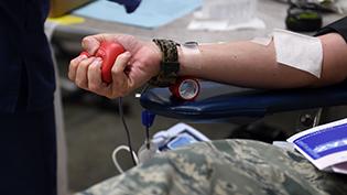 Medical staff draw blood from a man’s arm.